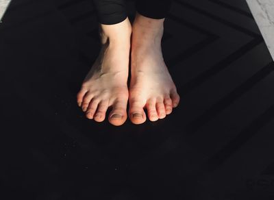 A person's feet firmly planted on a yoga mat.