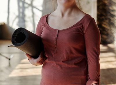 An empty yoga mat on a wooden floor, ready for practice.